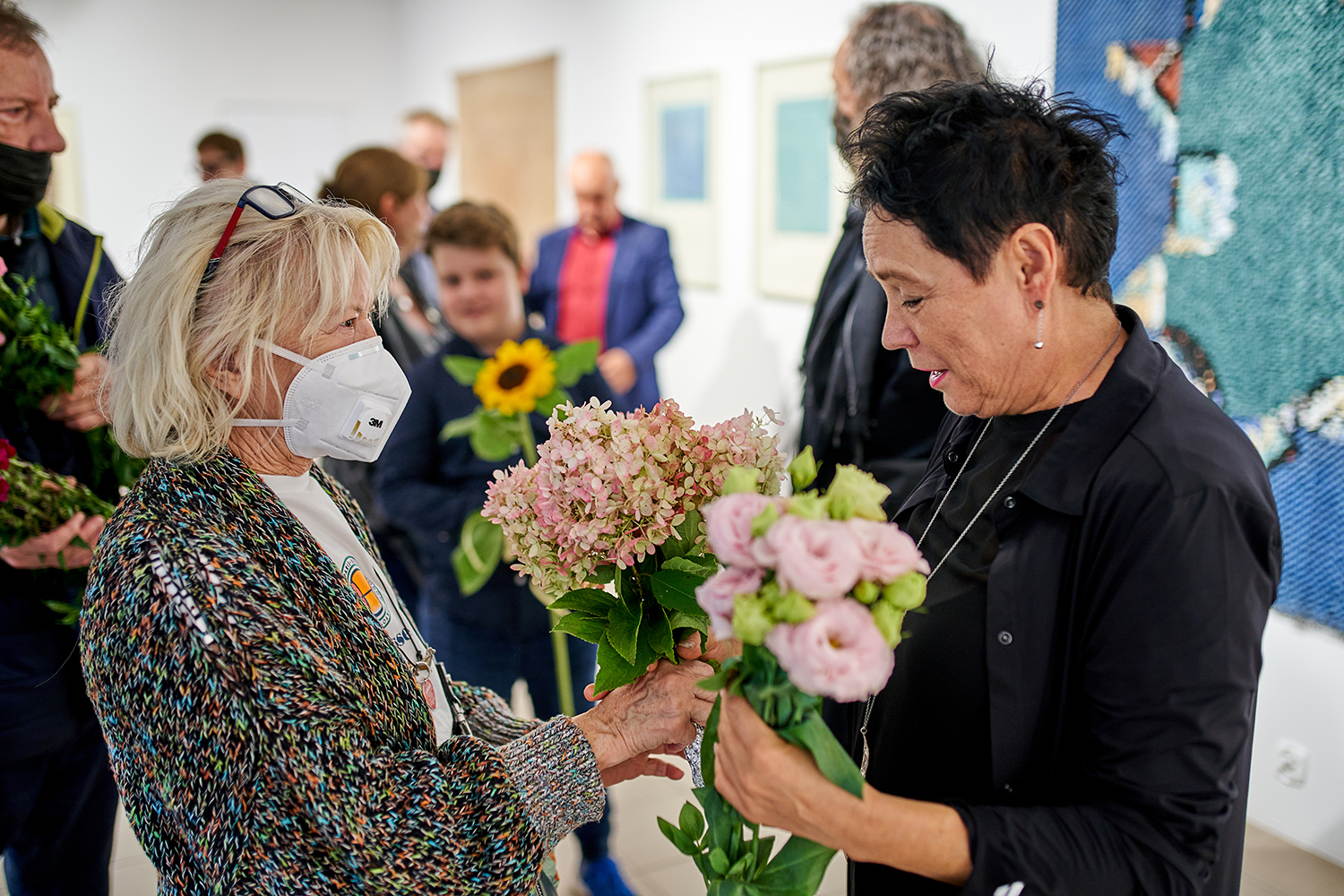 Ponownie prof. Jolanta Rudzka-Habisiak w otoczeniu kwiatów i ludzi, którzy oczekują, by wyrazić swoje uznanie.